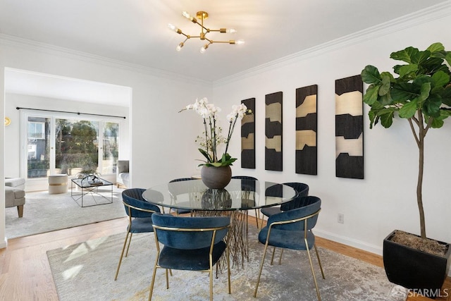 dining room with an inviting chandelier, hardwood / wood-style flooring, and ornamental molding