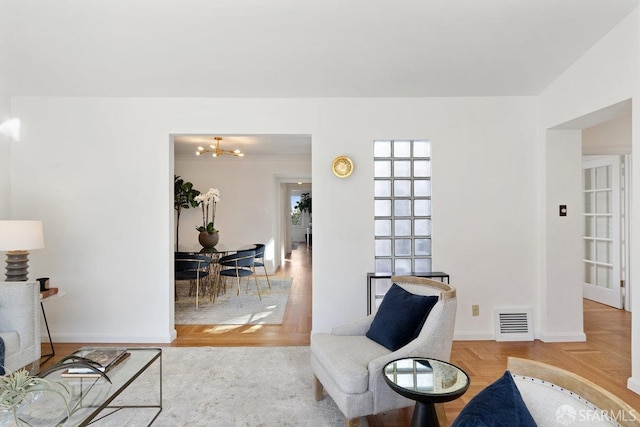 sitting room featuring an inviting chandelier and light parquet floors