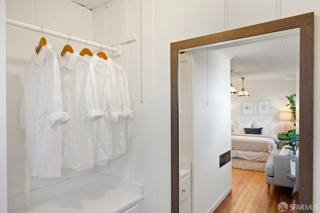 bathroom with hardwood / wood-style flooring and ornamental molding