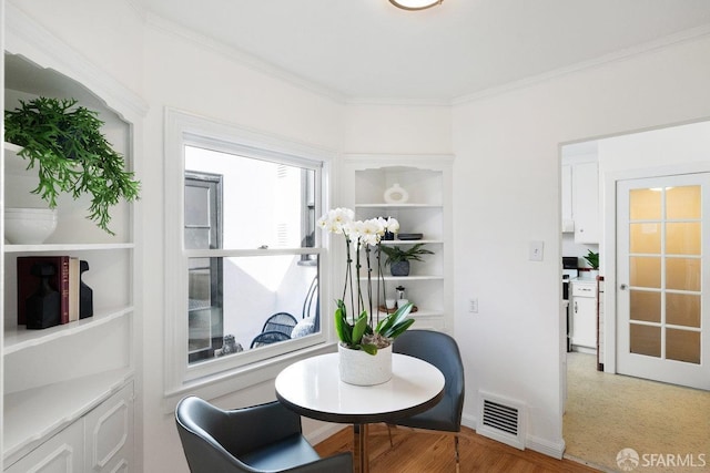 dining space featuring crown molding