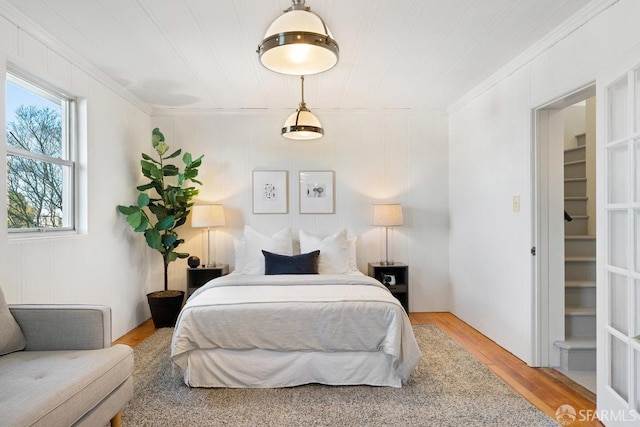 bedroom with crown molding and hardwood / wood-style floors