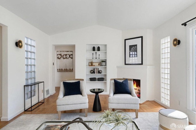 sitting room featuring lofted ceiling, hardwood / wood-style floors, and a wealth of natural light