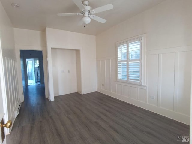 empty room with dark wood-type flooring, ceiling fan, and baseboard heating