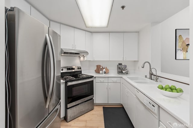 kitchen featuring appliances with stainless steel finishes, light hardwood / wood-style floors, white cabinetry, and sink