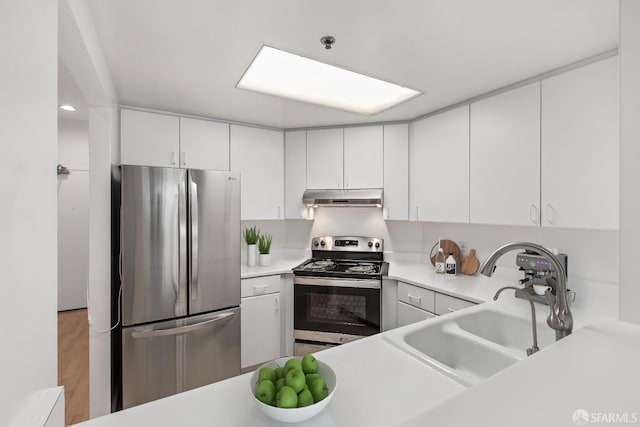 kitchen featuring appliances with stainless steel finishes, light hardwood / wood-style floors, white cabinetry, and sink