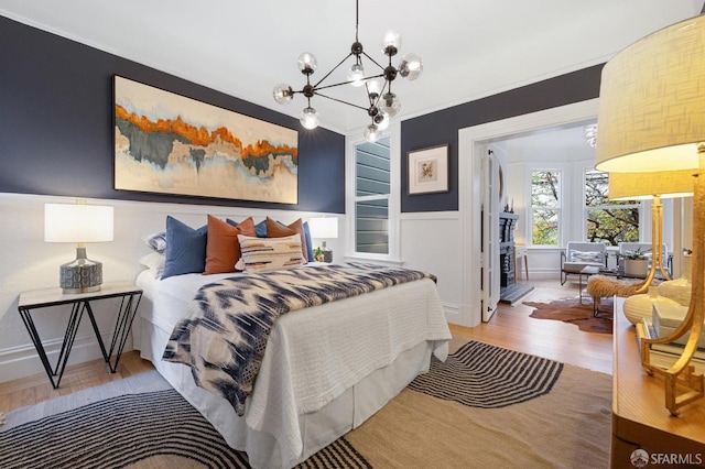 bedroom with crown molding, hardwood / wood-style floors, and a chandelier