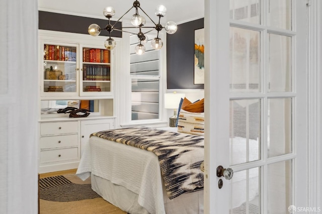 bedroom with an inviting chandelier and light hardwood / wood-style floors