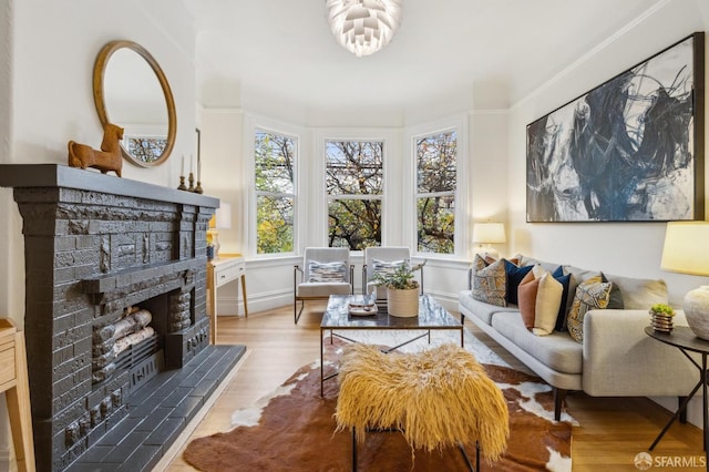 living room featuring a tiled fireplace and light hardwood / wood-style flooring