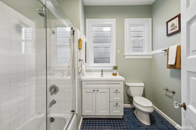 full bathroom featuring bath / shower combo with glass door, vanity, tile patterned floors, and toilet