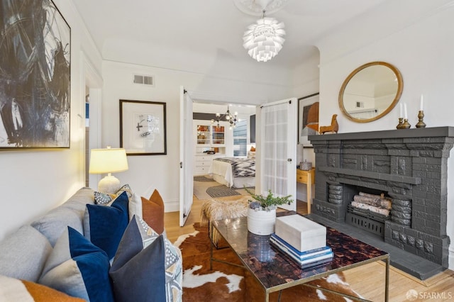 living room featuring hardwood / wood-style floors, a fireplace, and a chandelier