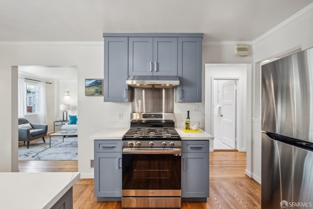 kitchen featuring under cabinet range hood, crown molding, stainless steel appliances, and light countertops