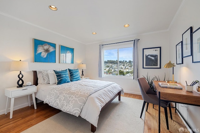 bedroom with recessed lighting, crown molding, baseboards, and wood finished floors