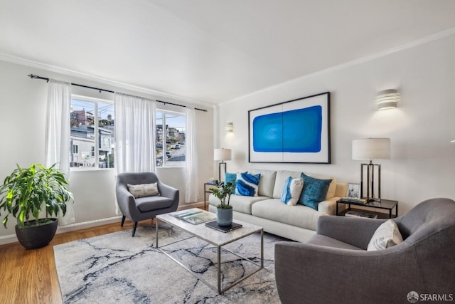 living area with crown molding, baseboards, and wood finished floors