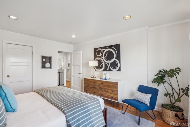 bedroom featuring baseboards, recessed lighting, wood finished floors, and crown molding