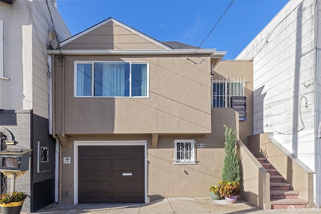 townhome / multi-family property featuring a garage and stucco siding