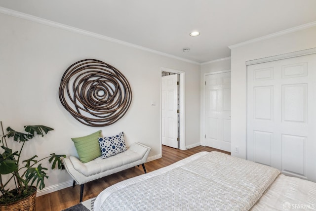 bedroom with recessed lighting, wood finished floors, baseboards, a closet, and crown molding