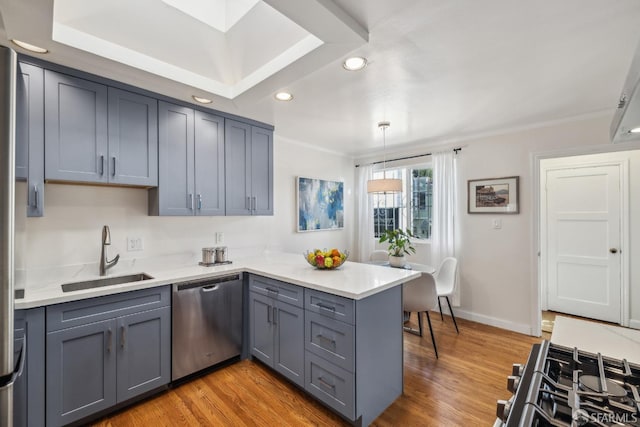 kitchen featuring dishwasher, a peninsula, gray cabinets, light wood-type flooring, and a sink