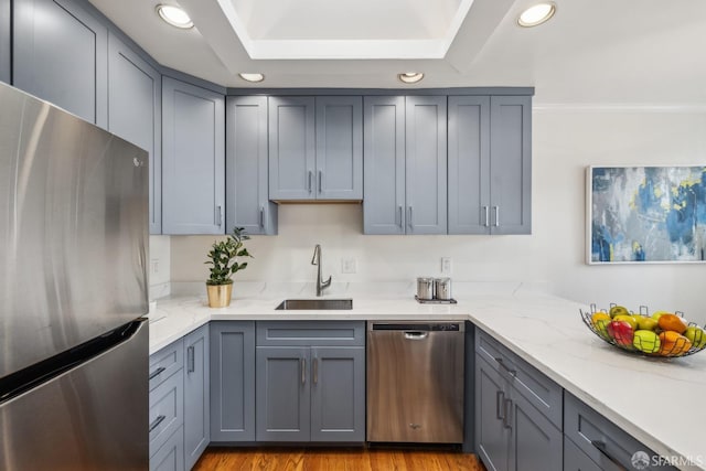 kitchen featuring appliances with stainless steel finishes, gray cabinets, a sink, and recessed lighting