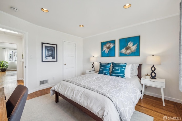 bedroom with baseboards, visible vents, wood finished floors, and recessed lighting