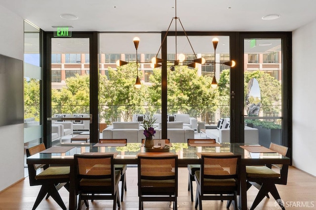 dining space featuring floor to ceiling windows and wood finished floors