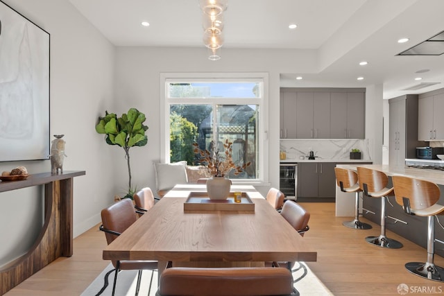 dining space featuring wine cooler and light hardwood / wood-style flooring