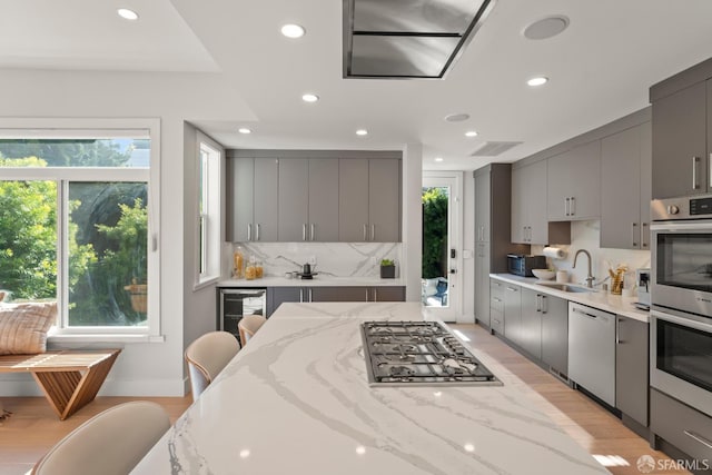 kitchen with appliances with stainless steel finishes, sink, and gray cabinetry