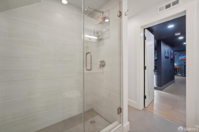 bathroom with hardwood / wood-style floors and a shower with shower door