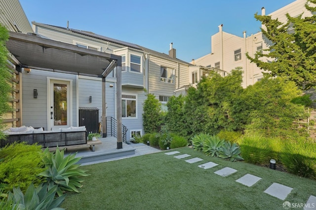 rear view of house with an outdoor living space and a lawn