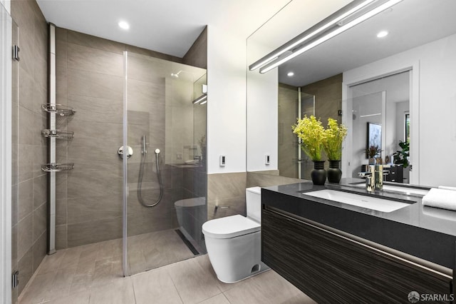 bathroom with tiled shower, vanity, and toilet