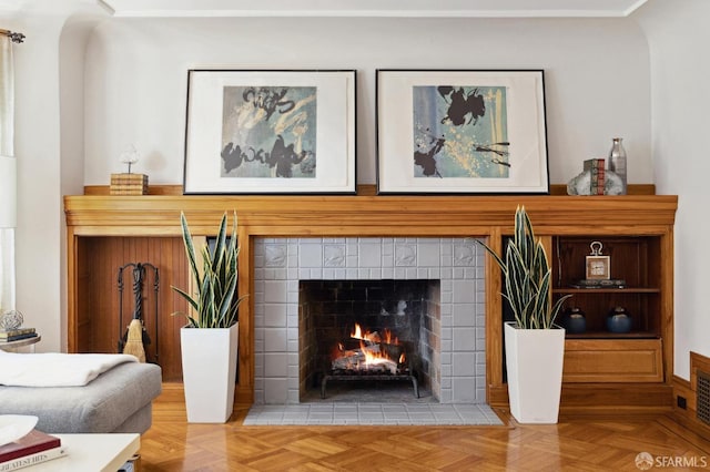 living room featuring parquet floors and a tiled fireplace