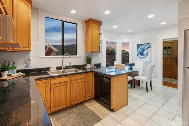 kitchen with kitchen peninsula, sink, light tile patterned floors, and black dishwasher