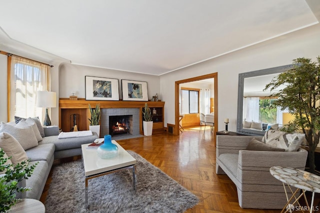 living room featuring dark parquet floors and a brick fireplace