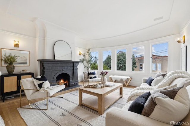 living room featuring a brick fireplace and light hardwood / wood-style flooring