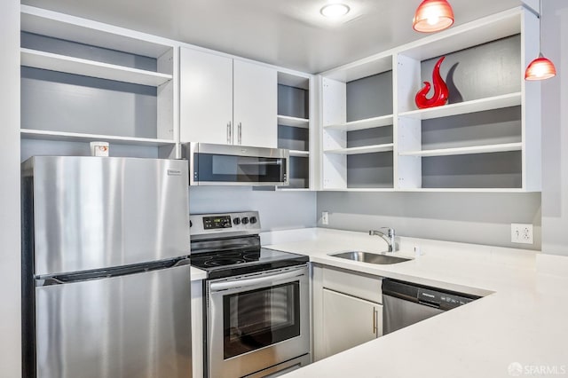 kitchen featuring stainless steel appliances, open shelves, a sink, white cabinets, and light countertops