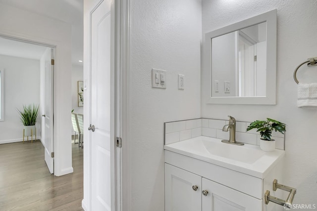 bathroom featuring baseboards, vanity, and wood finished floors