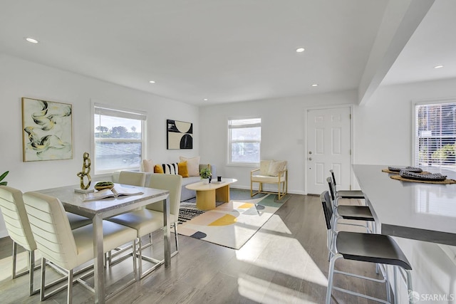 dining space featuring baseboards, recessed lighting, wood finished floors, and a healthy amount of sunlight