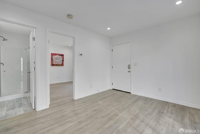 empty room with recessed lighting, light wood finished floors, and baseboards