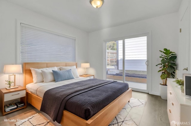 bedroom with light wood-type flooring and access to exterior