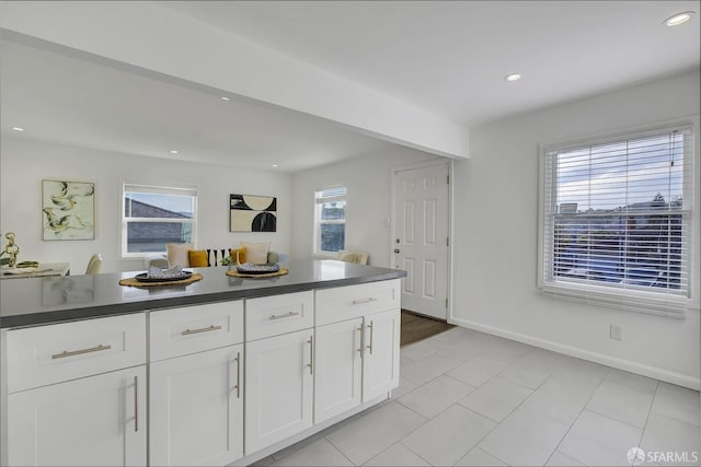 kitchen with light tile patterned floors, white cabinetry, recessed lighting, dark countertops, and baseboards