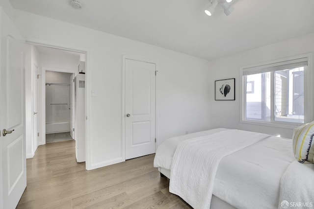 bedroom with light wood-style flooring and baseboards