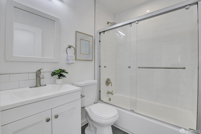 bathroom with shower / bath combination with glass door, vanity, and toilet