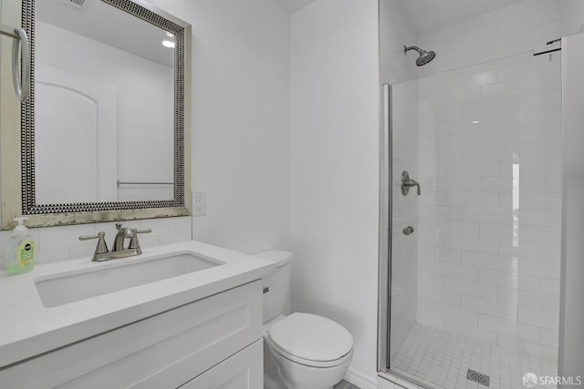 bathroom featuring a shower stall, vanity, and toilet