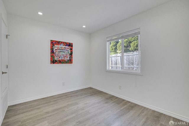 empty room with recessed lighting, baseboards, and wood finished floors