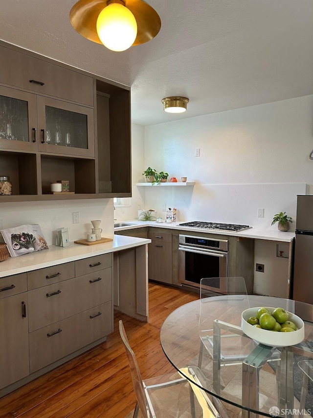 kitchen featuring gray cabinetry, appliances with stainless steel finishes, and light wood-type flooring