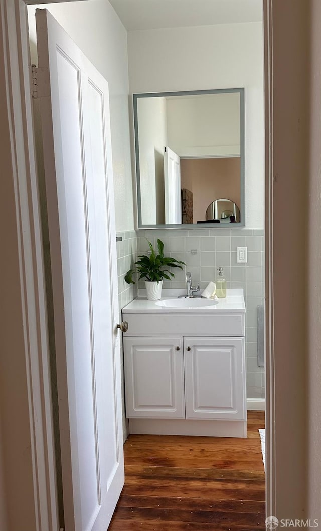 bathroom with vanity, wood-type flooring, and tile walls