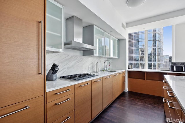 301 Mission St Unit 39A, San Francisco, CA 94105 - kitchen featuring wall chimney exhaust hood, a sink, stainless steel gas stovetop, decorative backsplash, and dark wood-style flooring