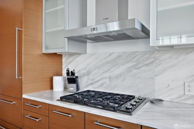 301 Mission St Unit 39A, San Francisco, CA 94105 - kitchen featuring extractor fan, backsplash, light countertops, stainless steel gas cooktop, and glass insert cabinets