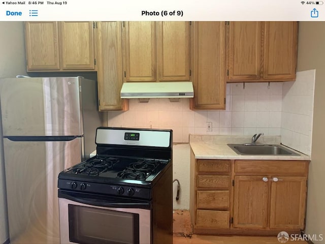 3-5 Sonoma St, San Francisco, CA 94133 - kitchen featuring stainless steel appliances, a sink, under cabinet range hood, light countertops, and tasteful backsplash