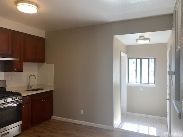 3-5 Sonoma St, San Francisco, CA 94133 - kitchen featuring stainless steel range with gas stovetop, a sink, under cabinet range hood, light countertops, and decorative backsplash