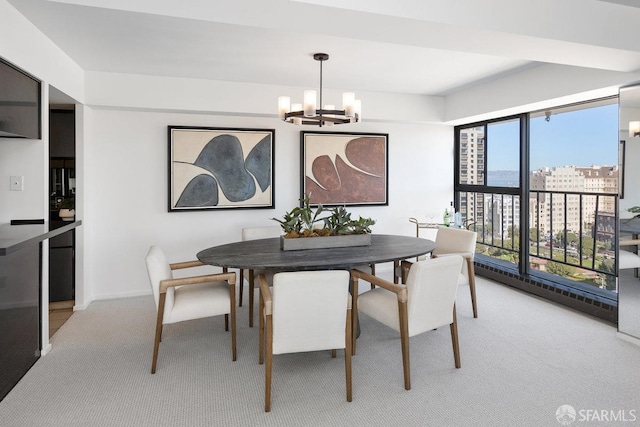 dining room with a view of city, light colored carpet, baseboards, and a chandelier